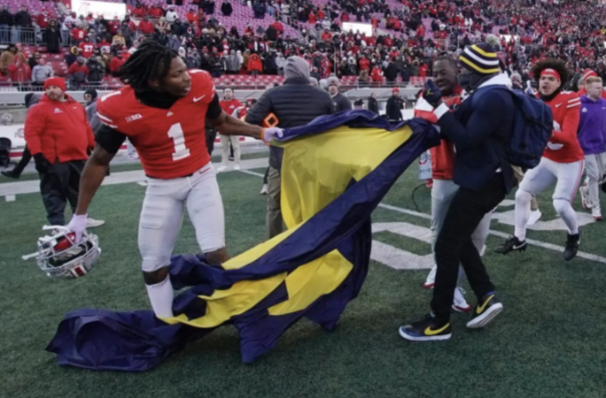 Ohio State player, Davidson Igbinoson, rips the Michigan flag away from their staff after the brawl breaks out in Ohio Stadium. Ohio State and Michigan fight by Austin Meek and Lauren Merola, via The New York Times
